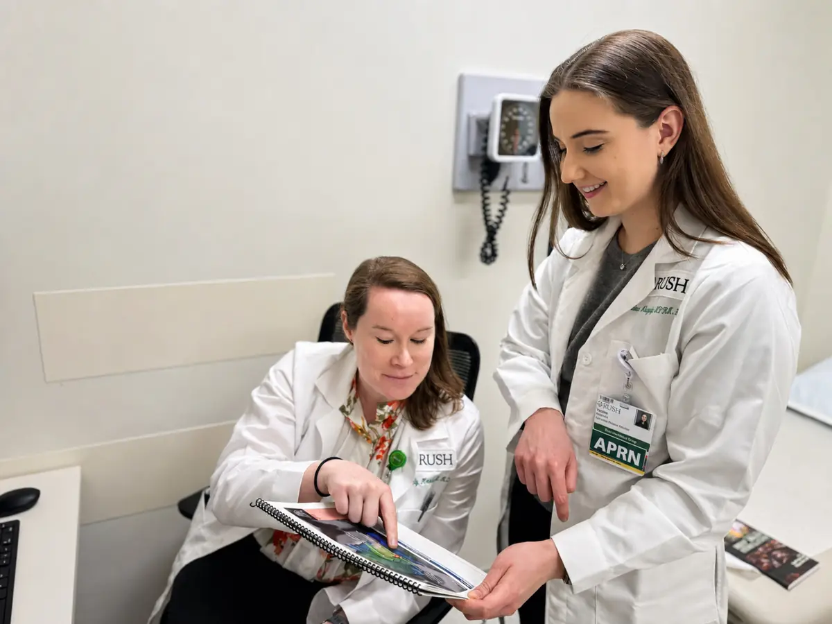 A physician and an advanced practice nurse going through the patient guide together