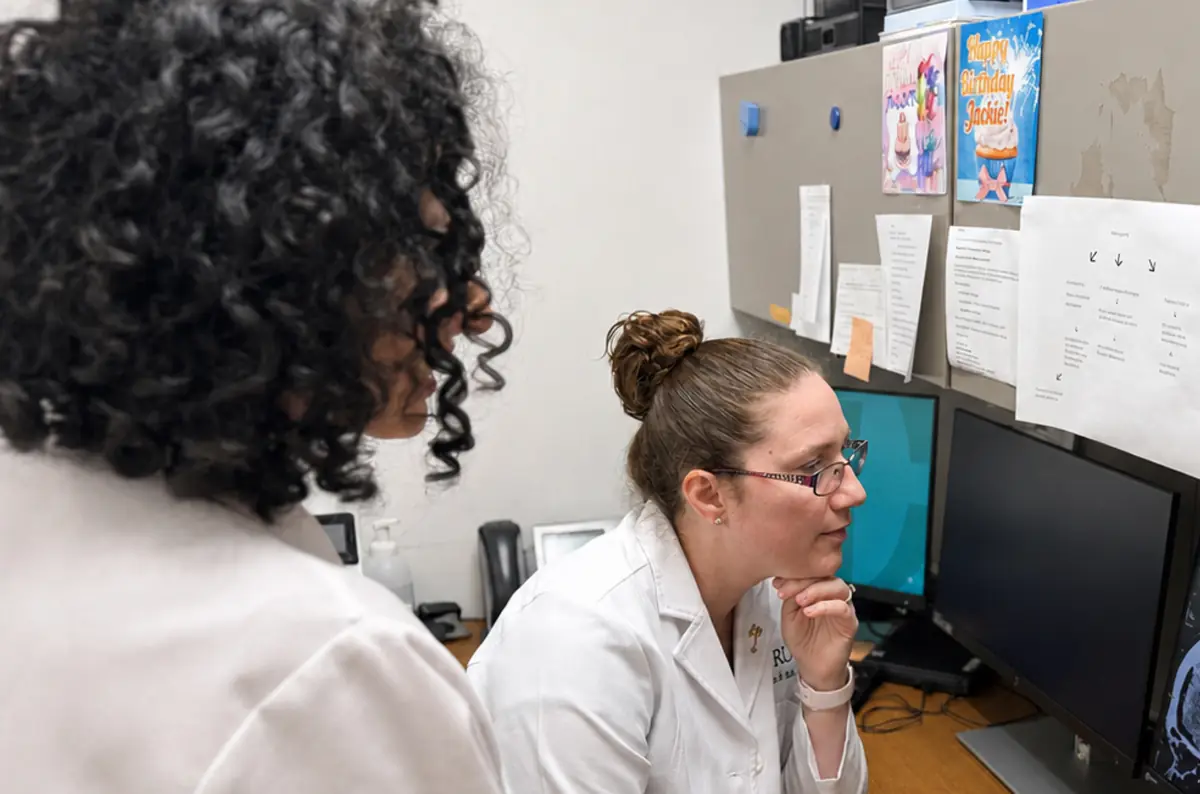 Two clinicians studying brain imaging side by side at a reading workstation